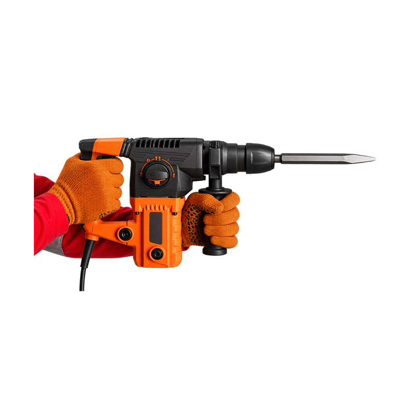 Orange-and-black corded chipping hammer held by gloved hands, with auxiliary grip and flat chisel pointing right.